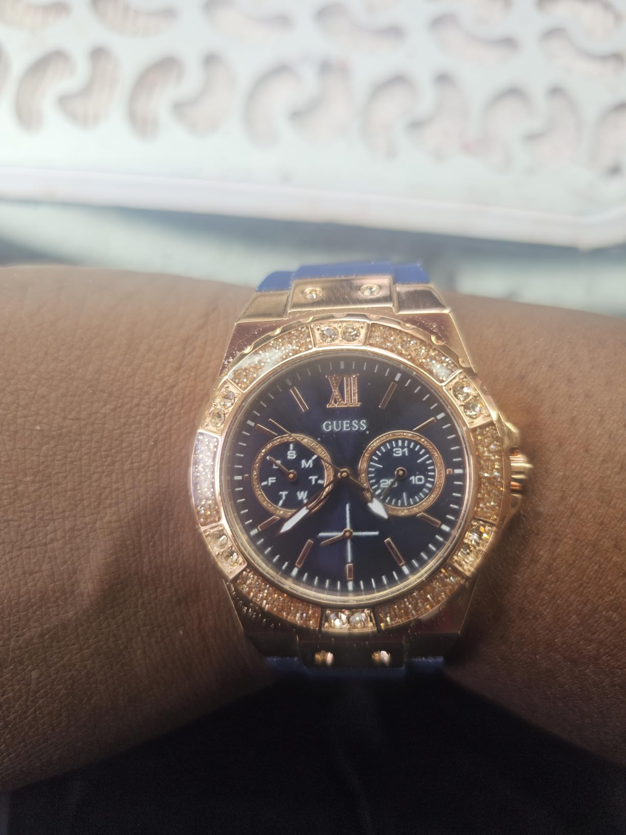 Relógio Guess rose gold no pulso feminino