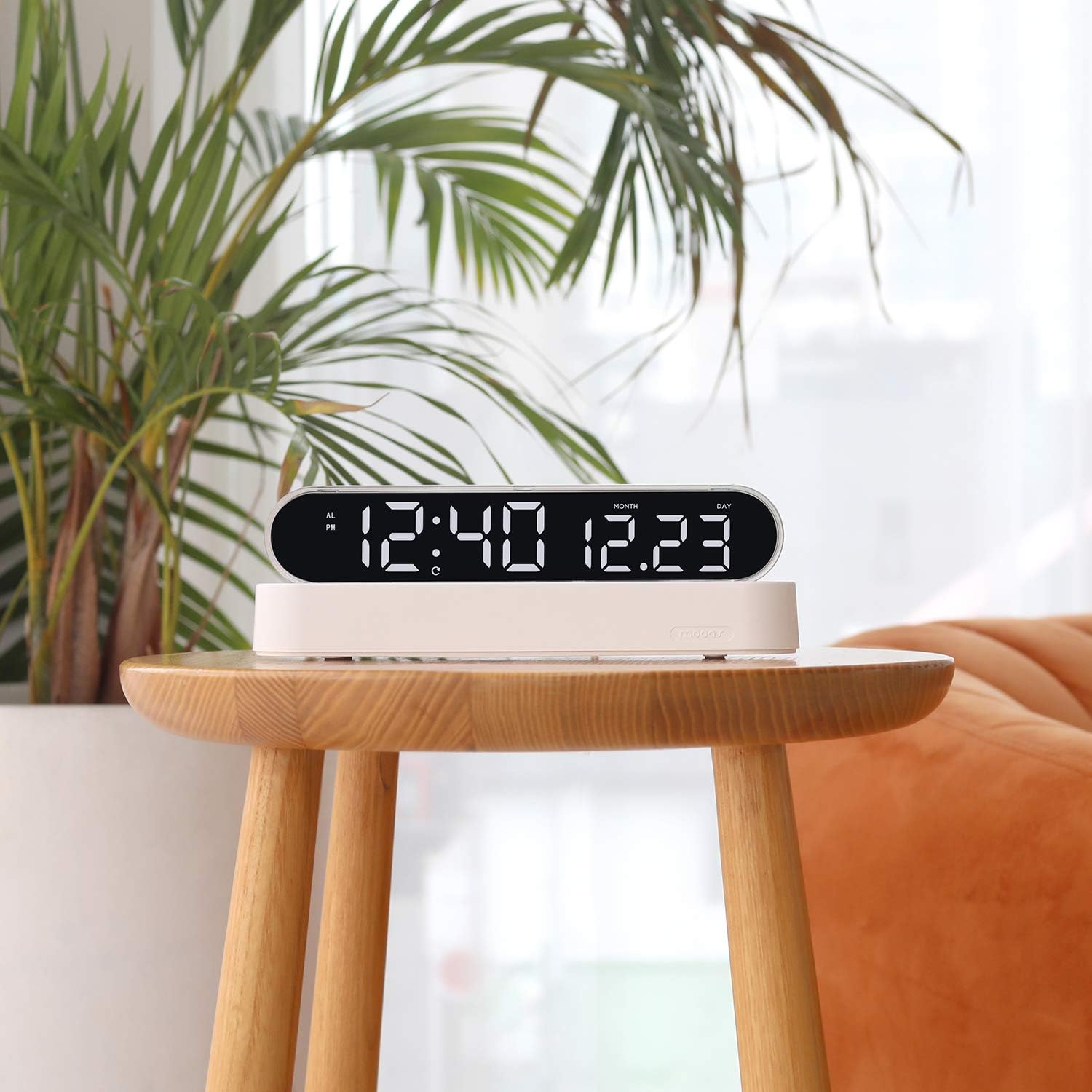Mooas Dual LED Moon Night Light Digital Alarm Clock on a wooden table, showing the clock display with white numbers and a warm yellow night light.