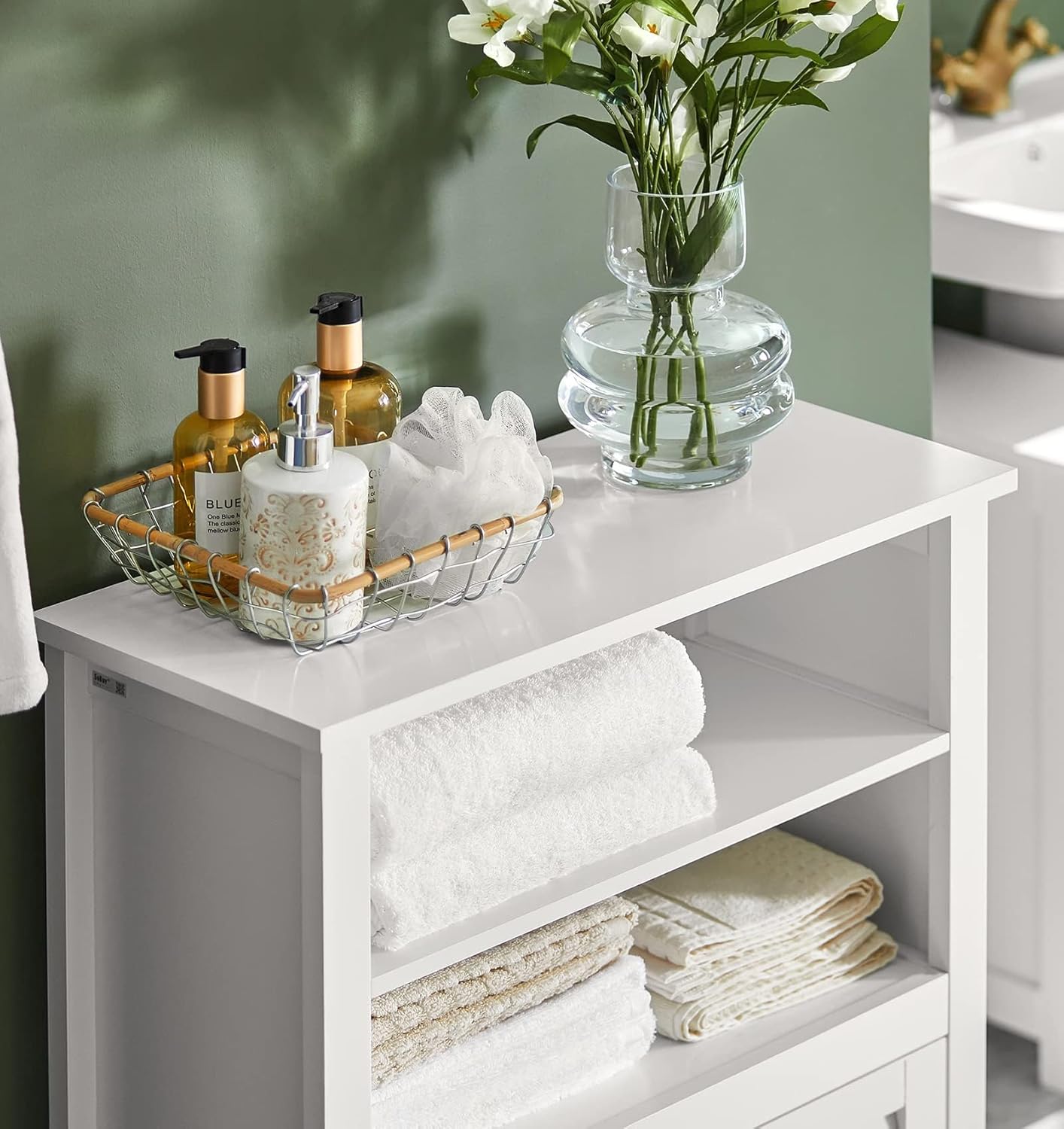 Close-up of the top open shelves of the SoBuy BZR13-W cabinet, neatly organized with towels and a decorative vase.