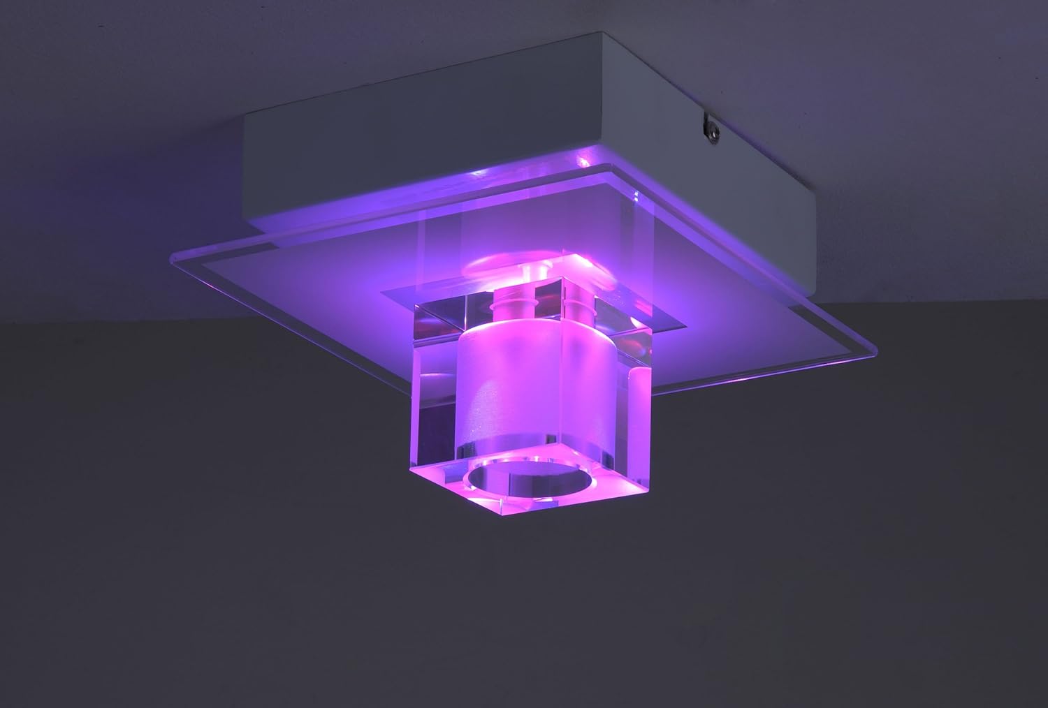 Leuchten Direkt TAKOS 50286-17 ceiling light illuminated with a bright purple light.