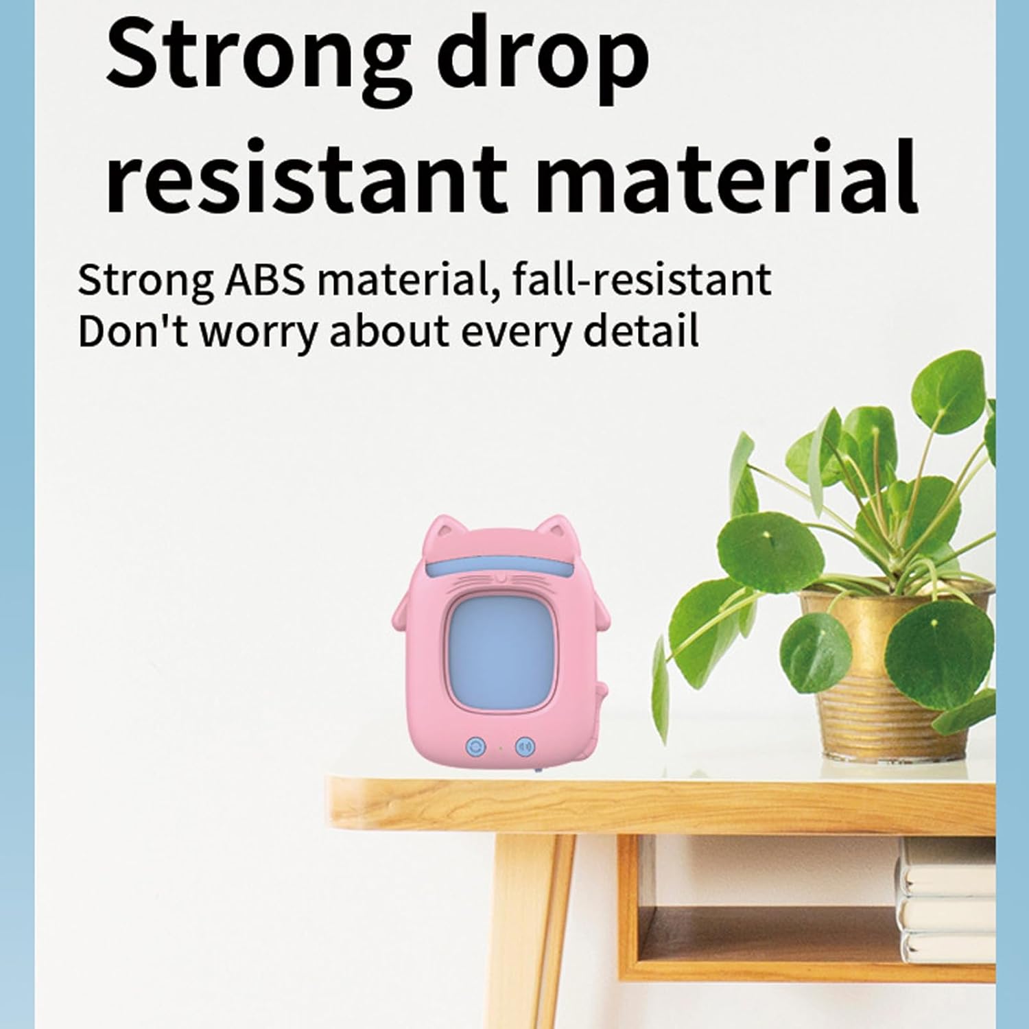 Pink cat-shaped early education device on a wooden table next to a potted plant, illustrating its durable construction.