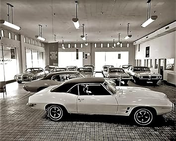 Home Comforts 1969 Pontiac Showroom Classic Car Dealership - Vintage Art Reproduction, Wall Decor 24x36 inches - Laminated Poster with Bright Colors and Vivid Details.