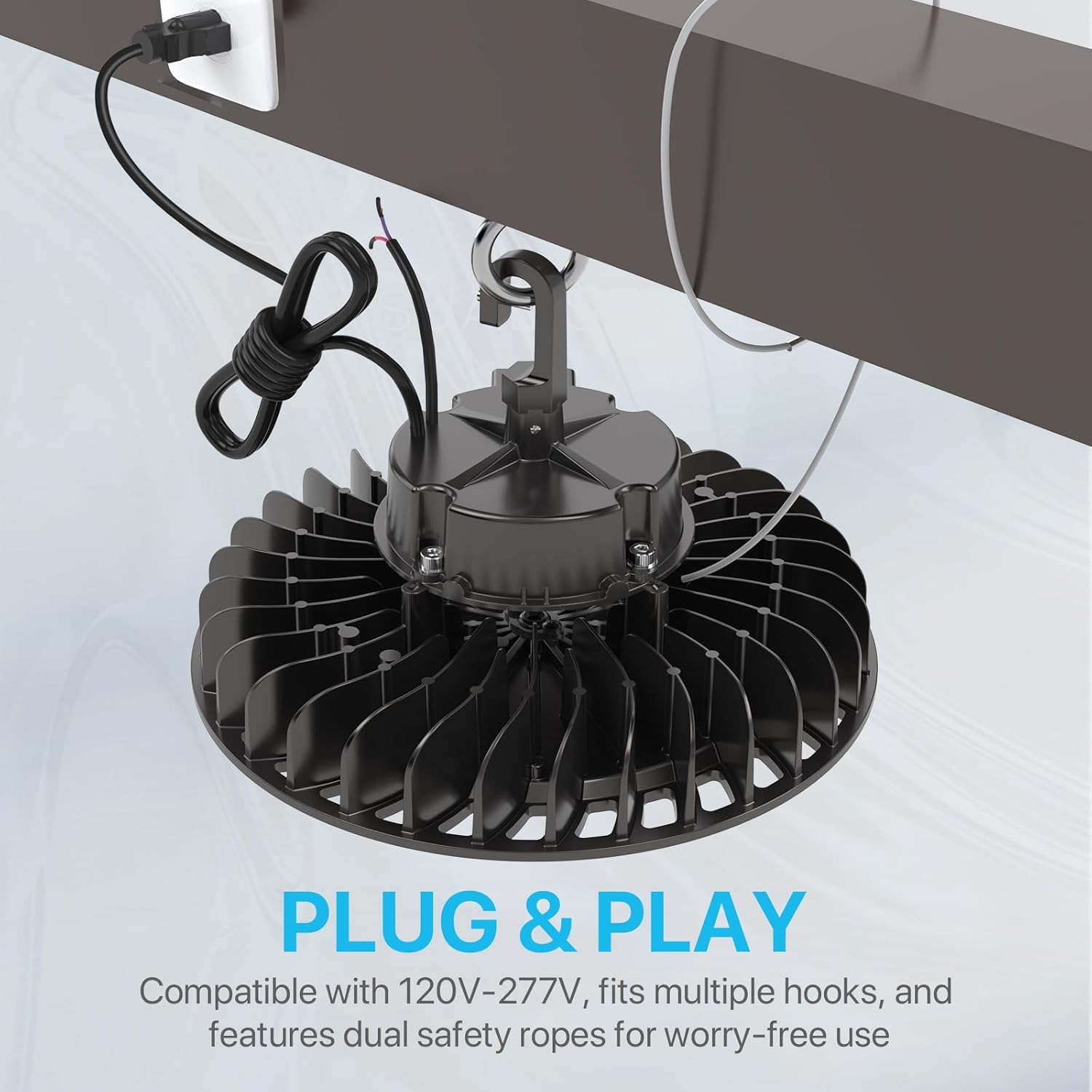 HYPERLITE LED UFO High Bay Light installed and plugged into a wall outlet, with text 'PLUG & PLAY - Compatible with 120V-277V, fits multiple hooks, and features dual safety ropes for worry-free use'.