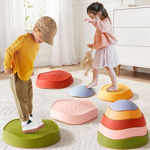 Two children moving across colorful textured stepping stones of different heights on a rug in a bright indoor room.