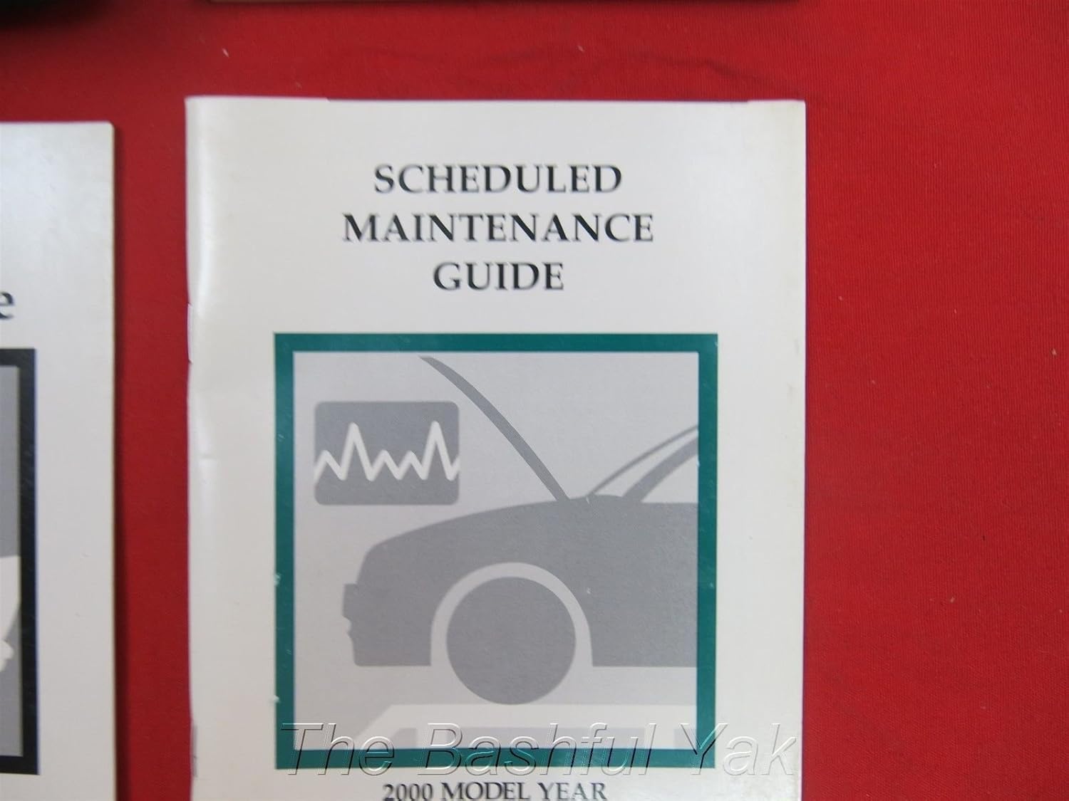 Cover of the 2000 Ford Scheduled Maintenance Guide, featuring the title 'SCHEDULED MAINTENANCE GUIDE' and a graphic of a car with its hood open.