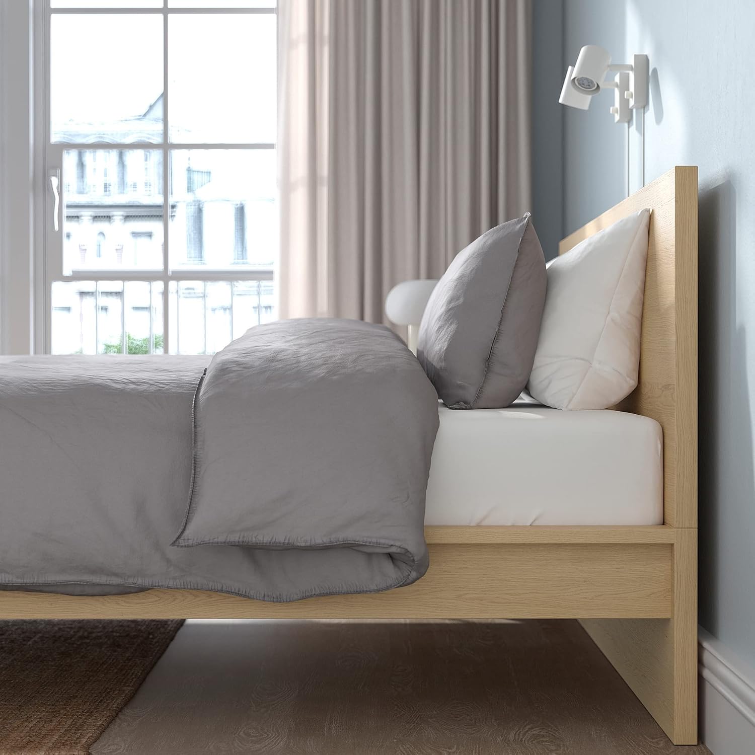 Side view of the IKEA MALM High Bed Frame with bedding, showing the height of the headboard