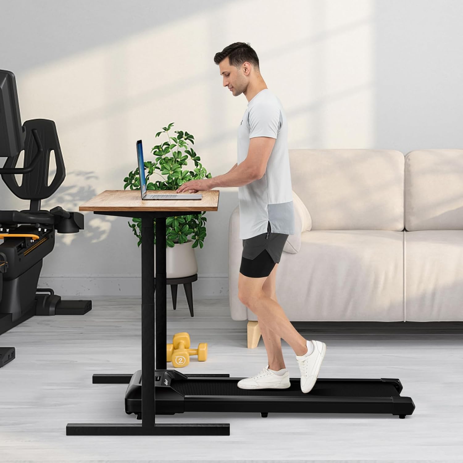 Man walking on the GYMAX Walking Pad under a standing desk.