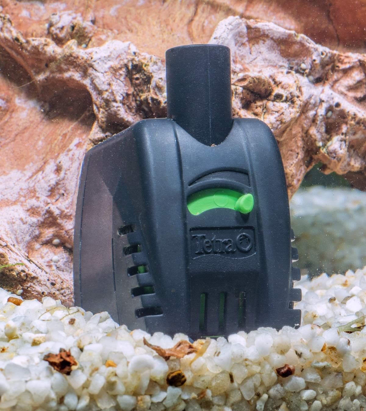Tetra WP Aquarium Pump submerged in an aquarium with white gravel and rock decorations.