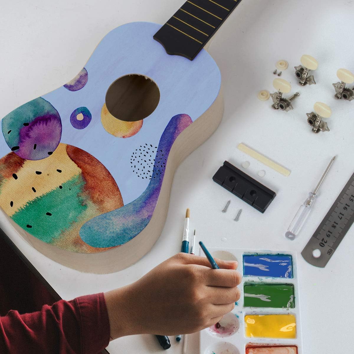 A partially painted ukulele kit, showing a colorful, artistic design on the body.