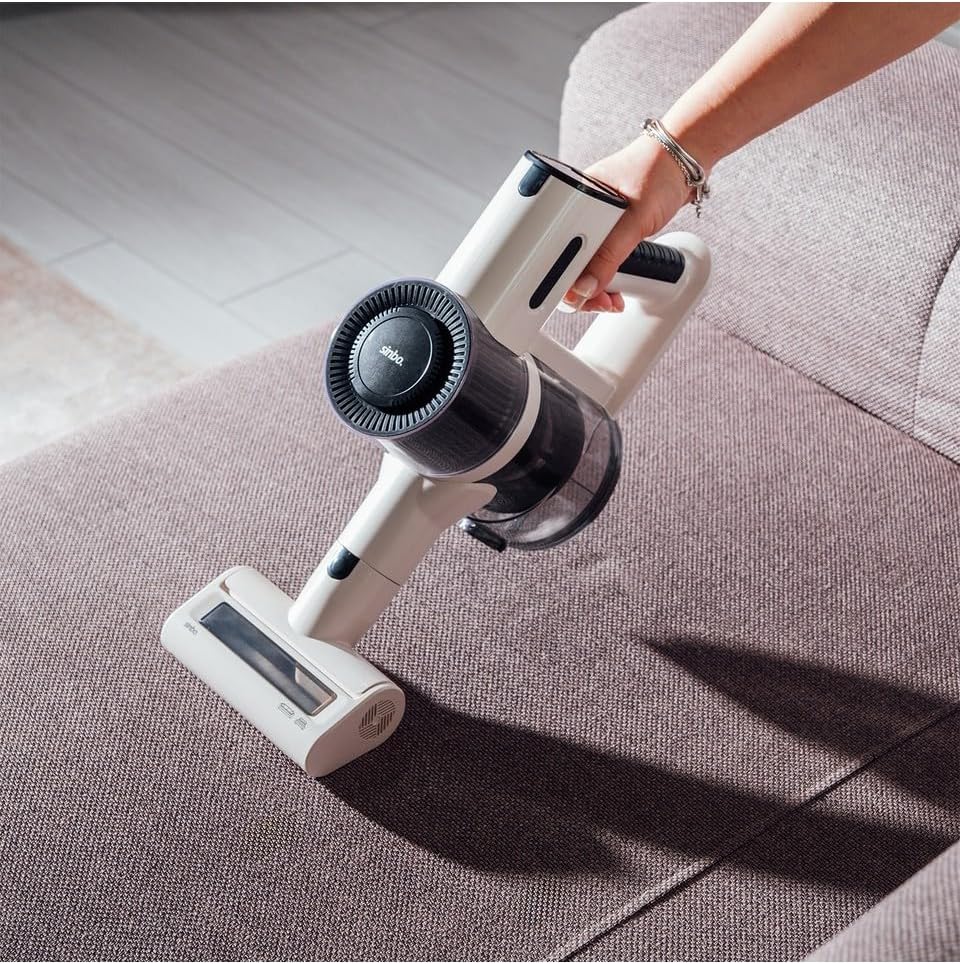 A person using the Sinbo SVC-8620 handheld vacuum cleaner to clean a sofa.