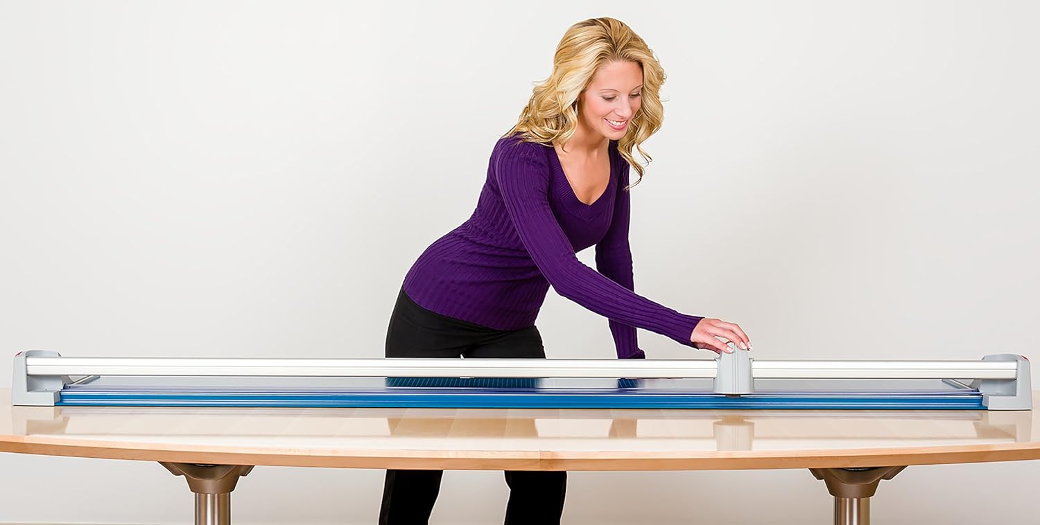 User operating Dahle 472 trimmer on a large sheet