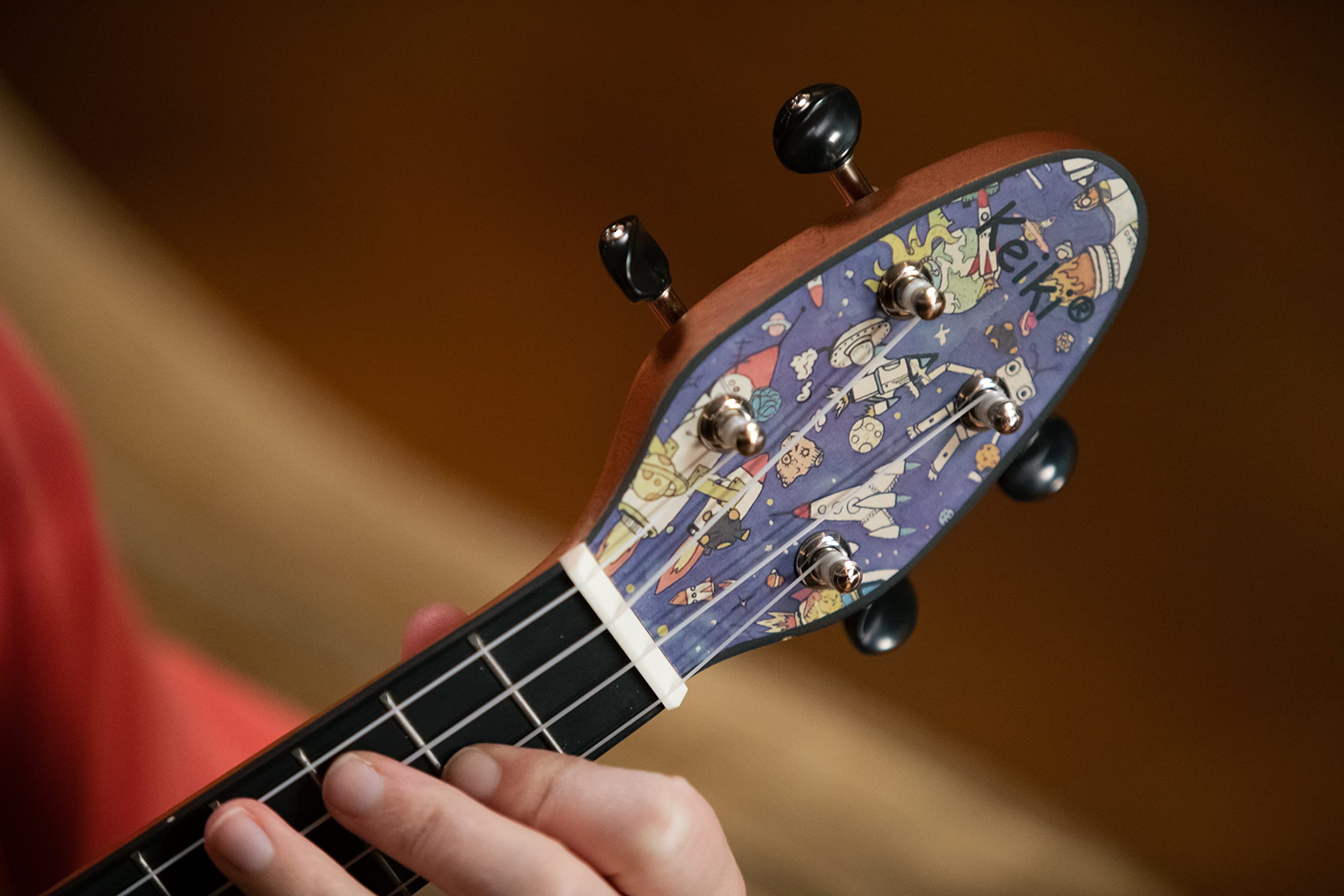 Ortega Guitars Akustyczne Ukulele Sopranowe – Seria Keiki K2 – w Zestawie z Akcesoriami – Agathis/ABS, Motyw Spaceman (K2-SP)
