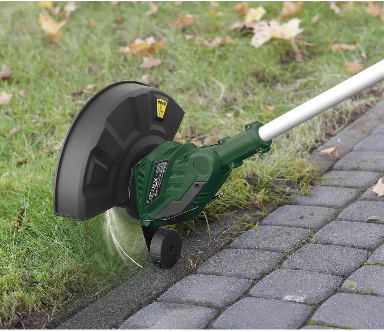 Grass trimmer in use, cutting grass in a garden