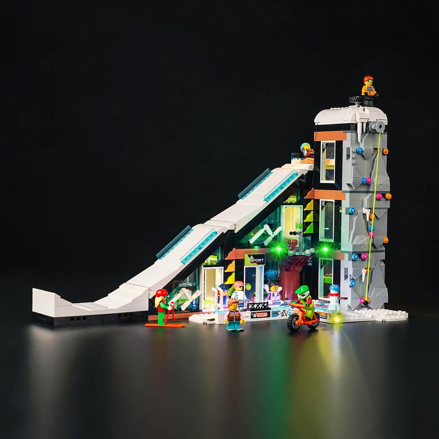 Fully assembled LEGO City Ski and Climbing Center model illuminated by the Hilighting LED Light Kit, showcasing various lit sections.