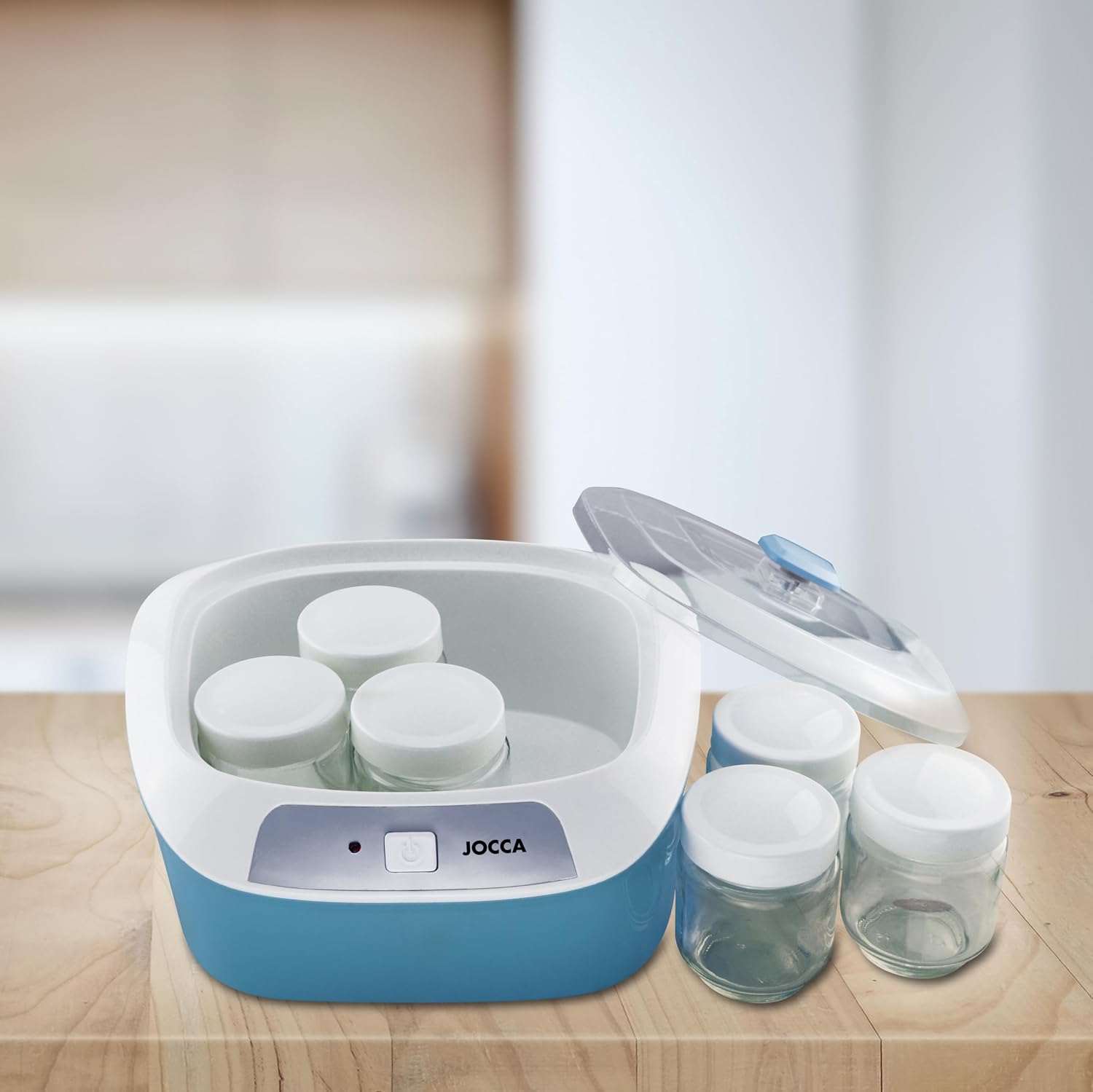 Jocca Yoghurt Maker with lid off, showing jars and one jar removed.
