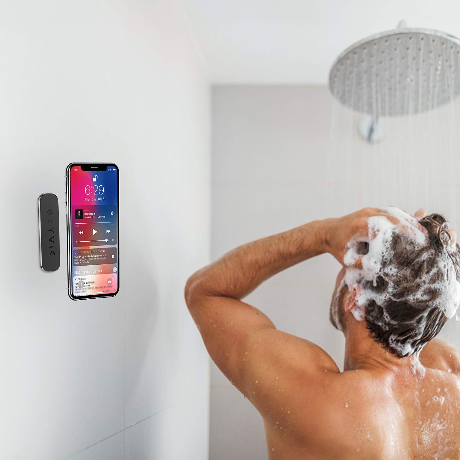 A smartphone mounted on a shower wall using the SKYVIK TRUHOLD magnetic mount, showing a person showering in the background.