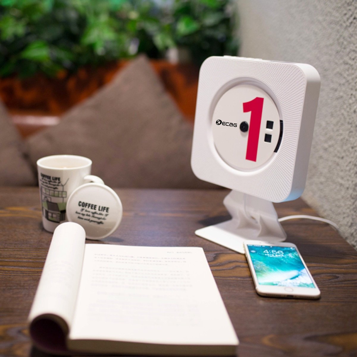KECAG CD Player on a desk stand next to a phone and book