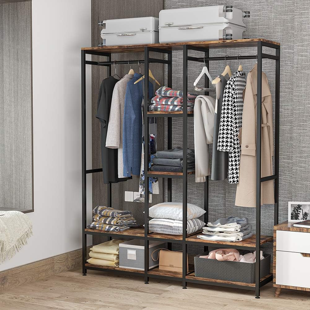 Tribesigns Double Rod Free Standing Closet Organizer in a room, showcasing various clothes hung on rods and folded on shelves, with suitcases on top.
