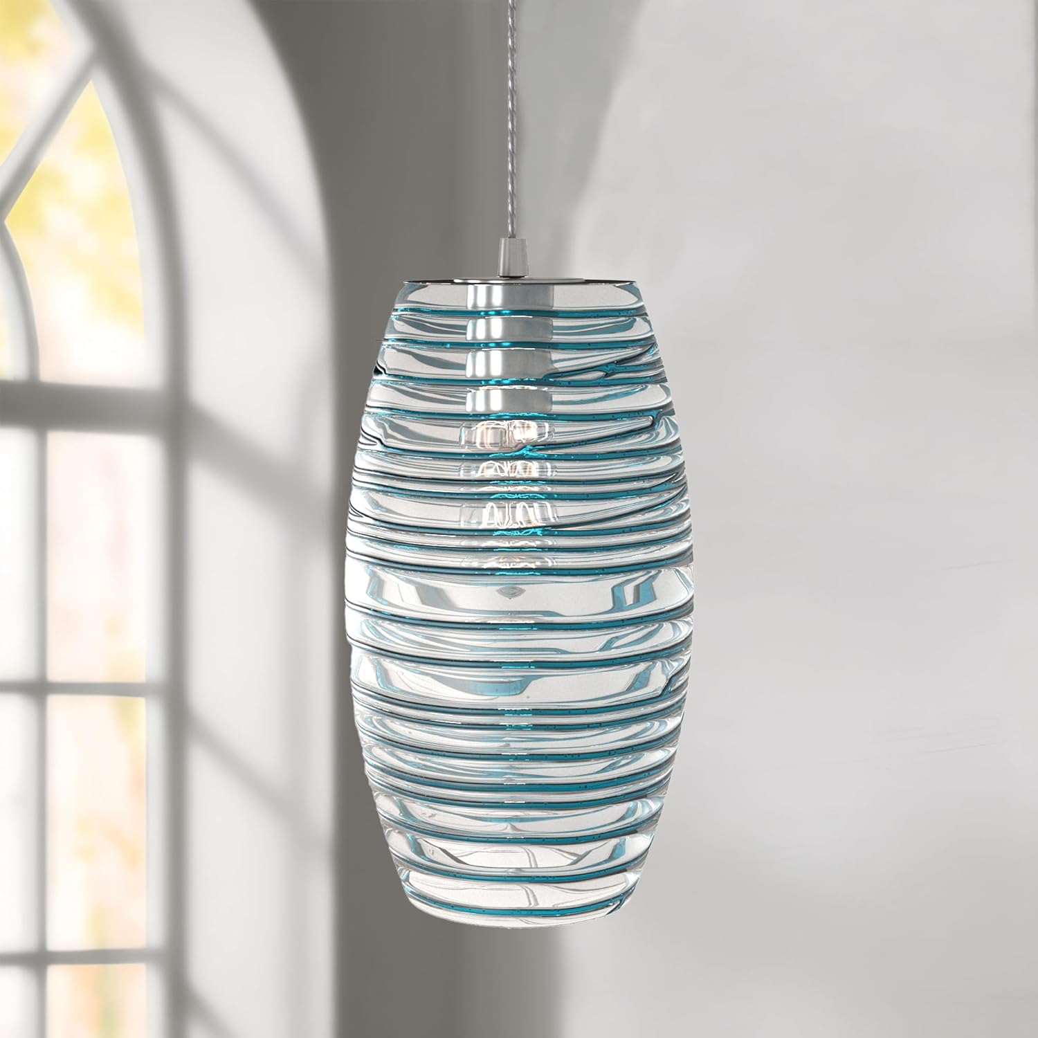 Maxax Blue Pendant Light with clear glass shade and blue swirl pattern, hanging in a room with a window in the background.