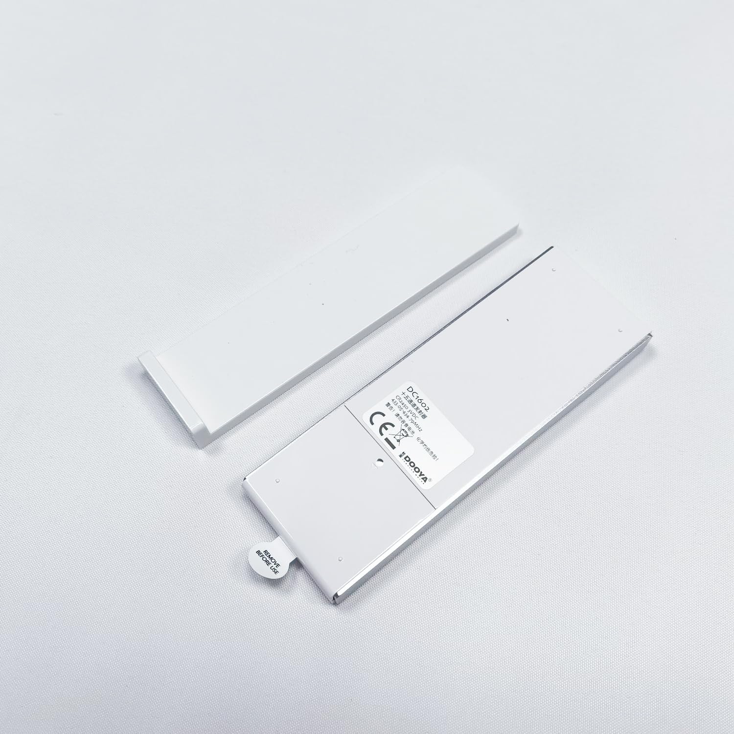 Dooya DC1602 remote control with back cover removed, showing battery compartment