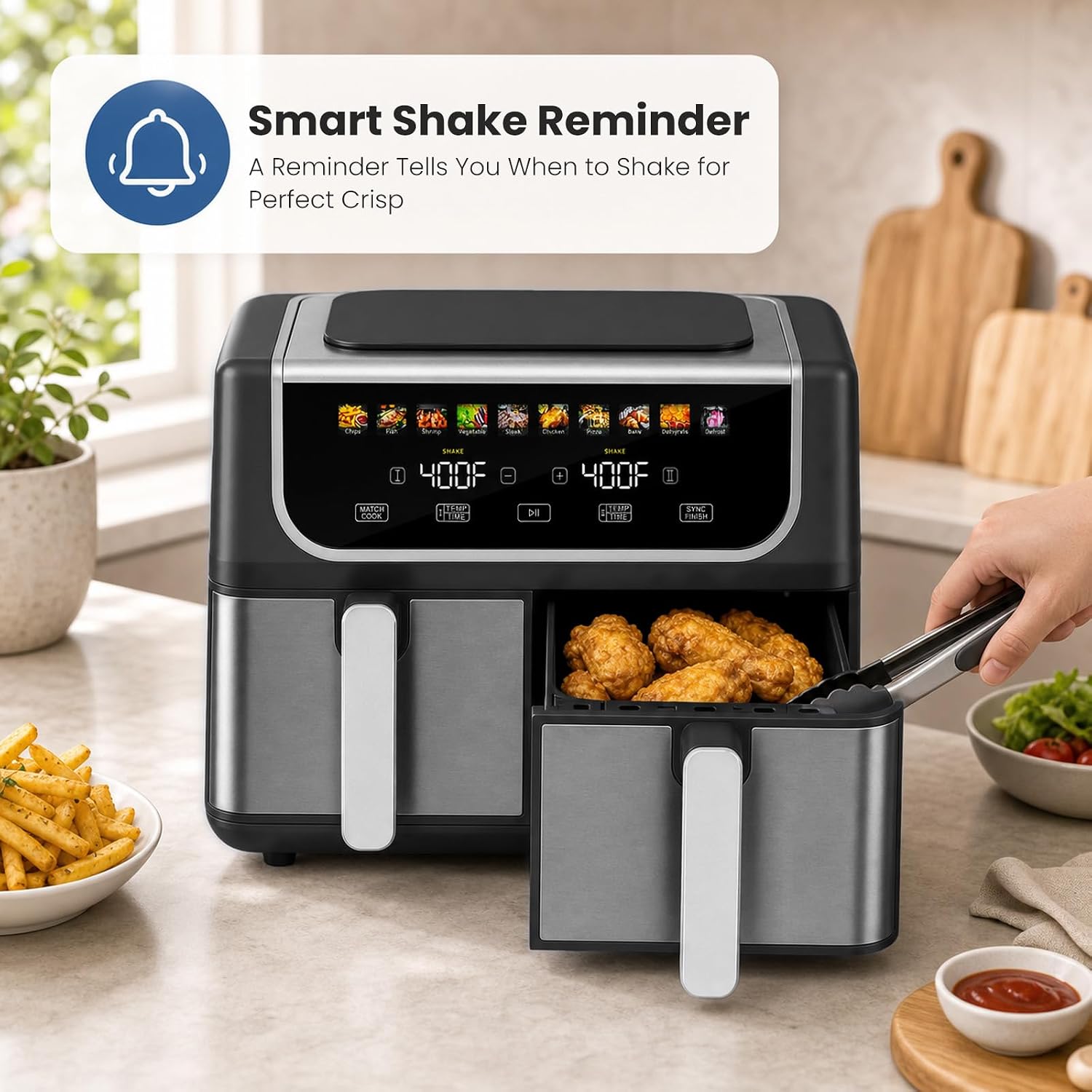OLIXIS Dual Basket Air Fryer showing a 'SHAKE' reminder icon on the display, with a hand shaking one of the cooking baskets.