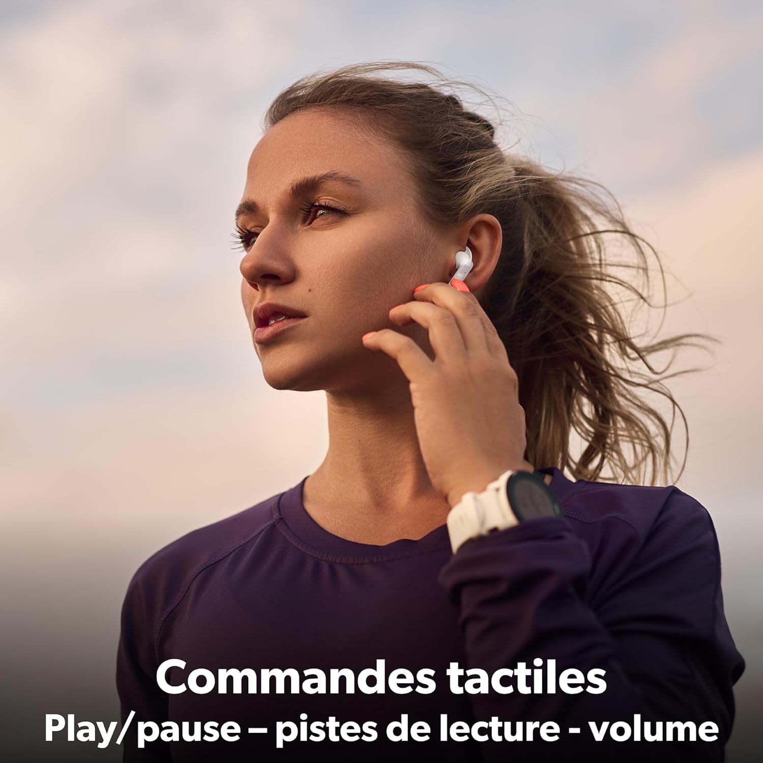 A person touching their T'nB Astro earbud, with text indicating touch controls for play/pause, tracks, and volume.