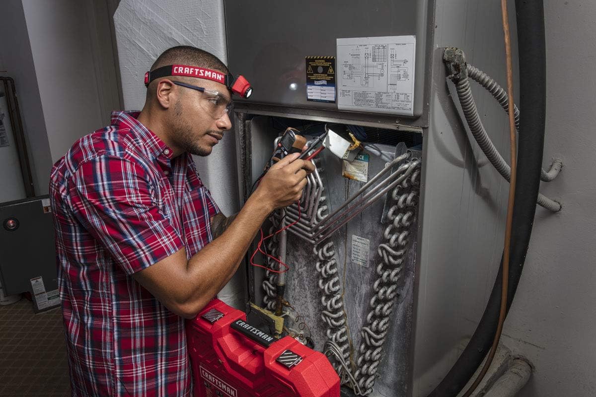 Man working on HVAC unit with CRAFTSMAN headlamp