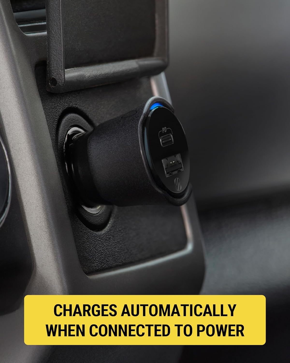 Close-up of the Scosche FoundIT Charge 32W Car Charger in a vehicle's 12V power outlet, showing a blue indicator light