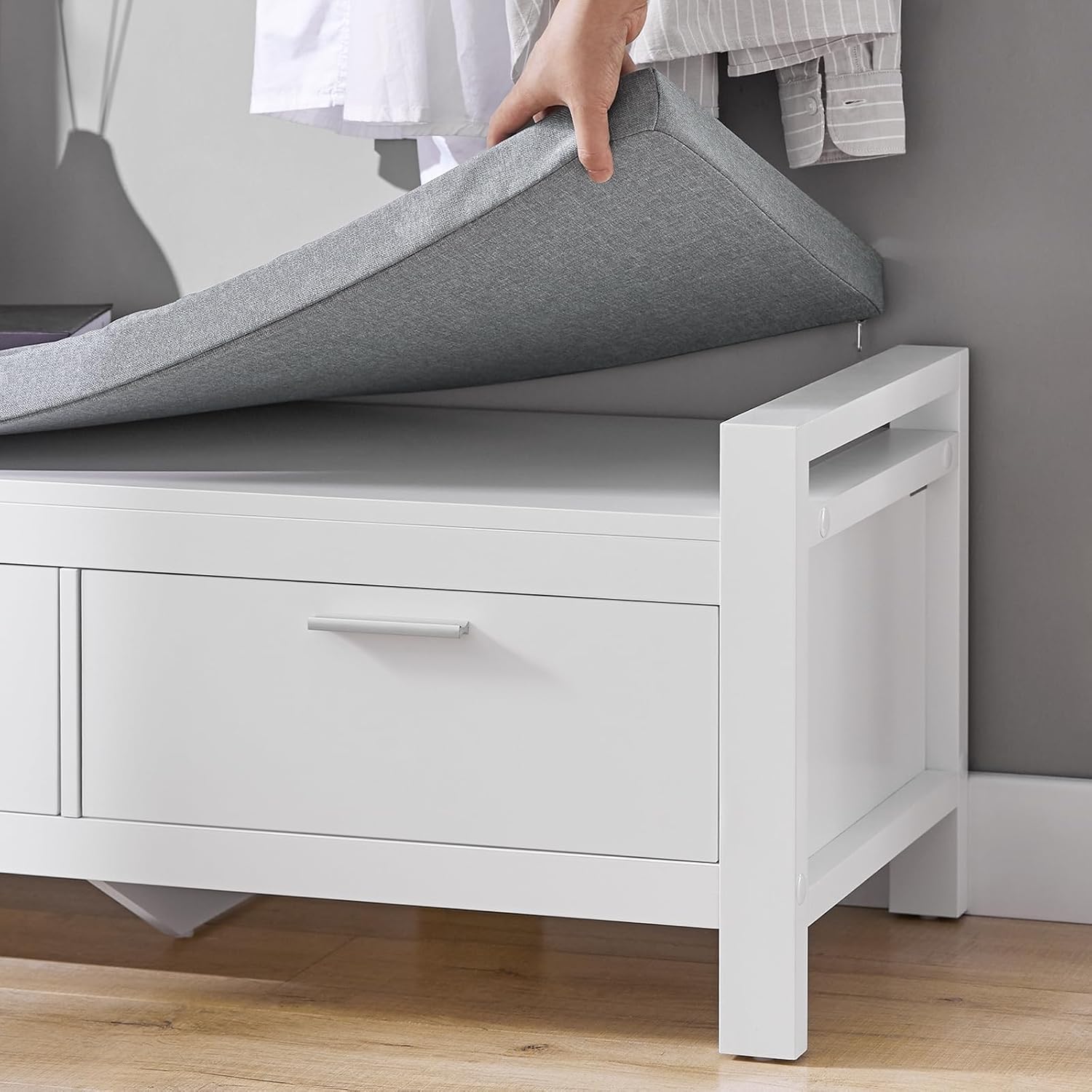 Hand lifting the grey padded cushion of the SoBuy FSR74-W Shoe Cabinet Bench.