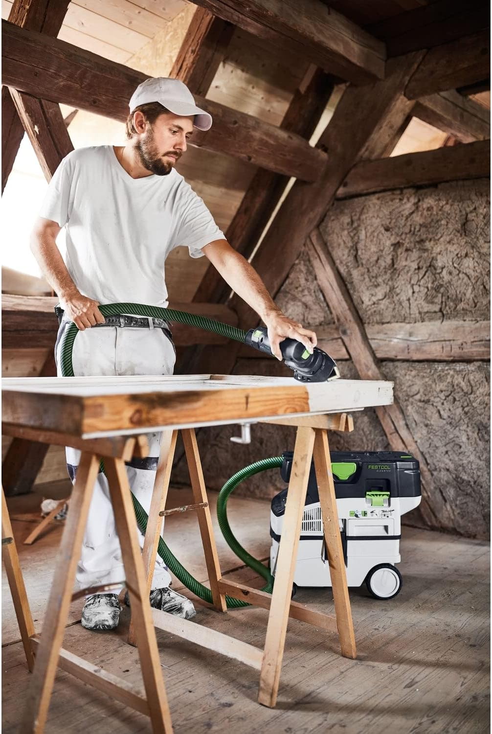 Close-up of a hand guiding the Festool DTSC 400-Basic sander across a wooden surface.