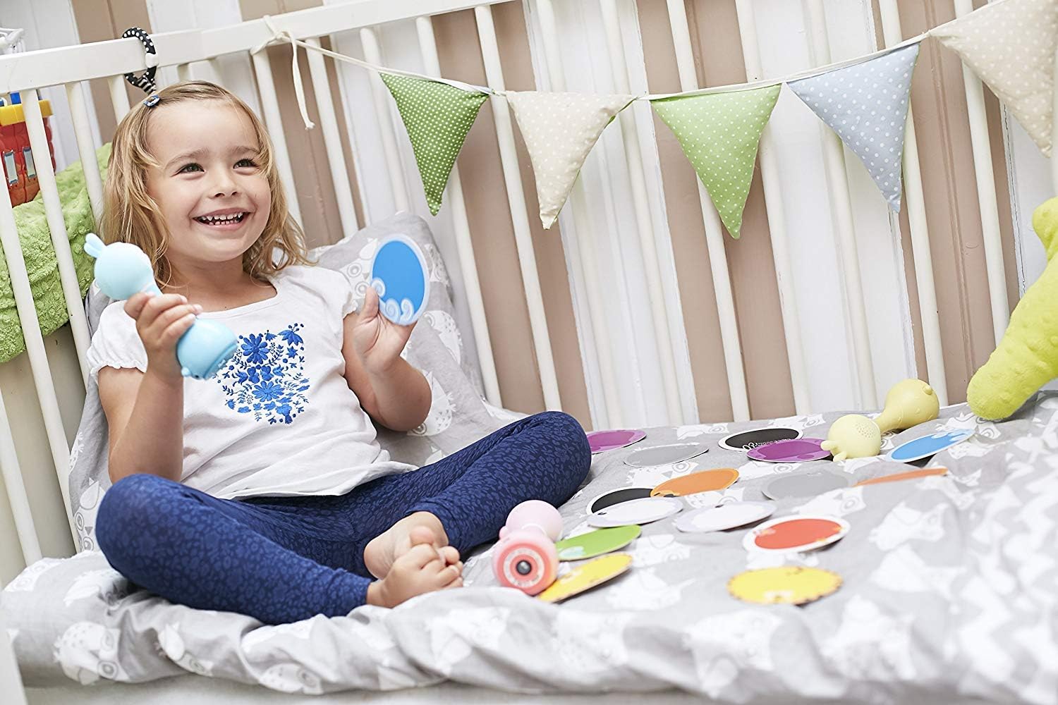 A baby sleeping peacefully in a crib with a blue Alilo Smart Bunny placed nearby, illustrating its use as a sleep aid.