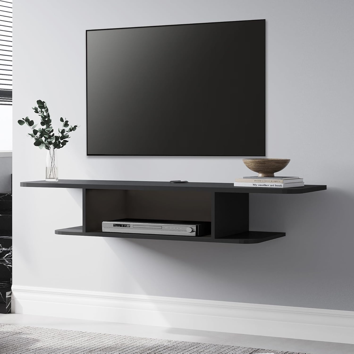 FITUEYES Floating TV Stand Shelf installed below a wall-mounted television, with a vase and books on top.