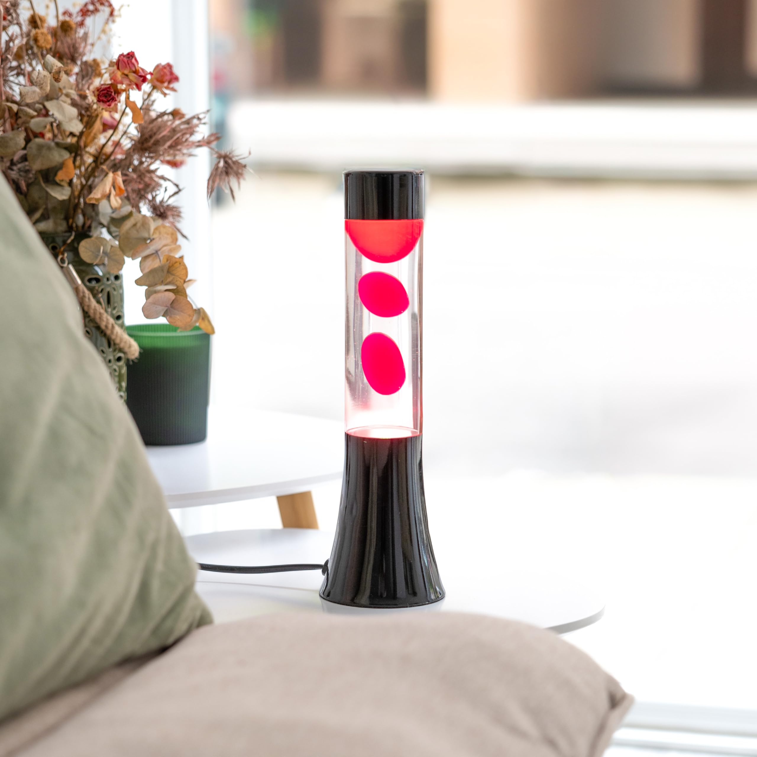 Fisura - Różowa lampa lawa. Lampa lawa o wysokości 30 cm z czarną podstawą, różową lawą i przezroczystym płynem. Relaksująca lampa. 9x9x30 cm