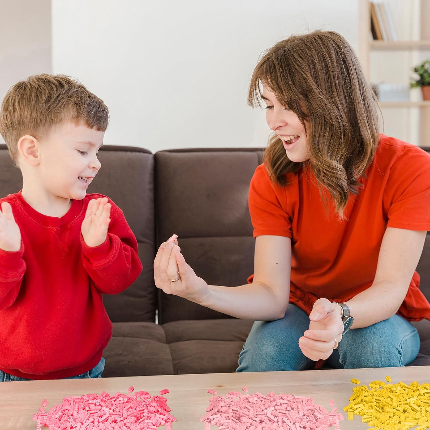 Voksne og børn sorterer og samler byggeklodser