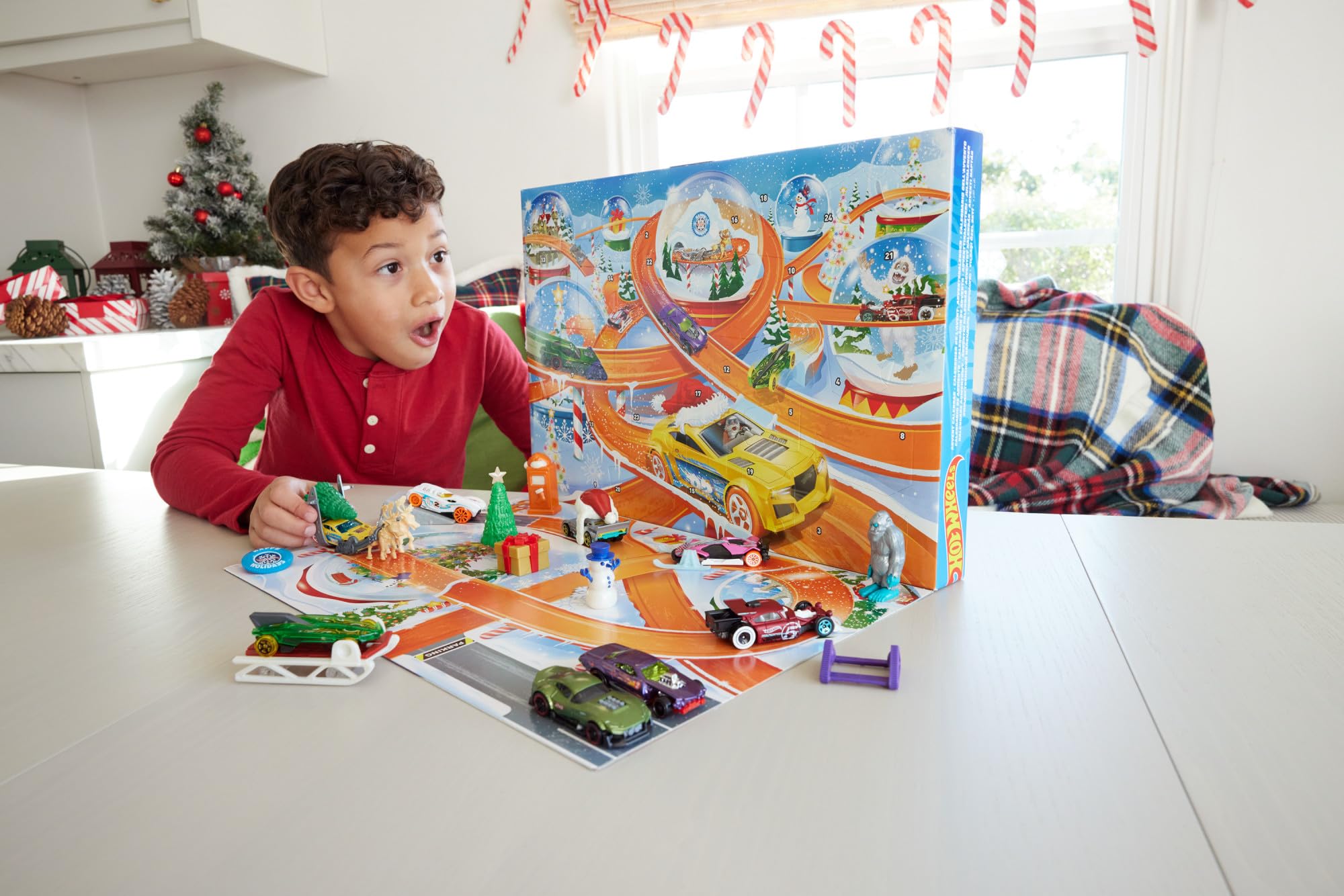 Hot Wheels - Calendario dell'Avvento 2024, 24 finestrelle numerate con sorprese e tappetino di gioco, 8 macchinine e 16 accessori a tema invernale, giocattolo per bambini, 3+ anni, HTG00