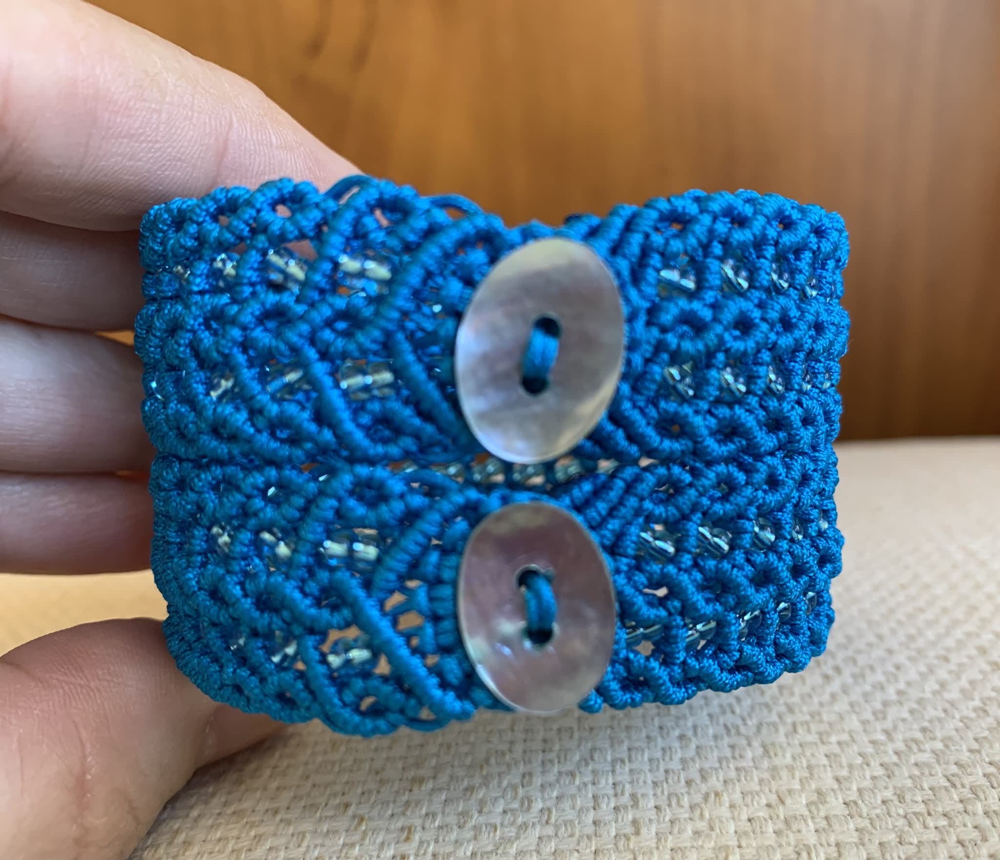 Pulsera macramé ancha azul hecha a mano con pequeñas rocallas cristal a juego Mide aprox.17,5 cm. de largo y 4 cm. de ancho.Cierra con dos botones