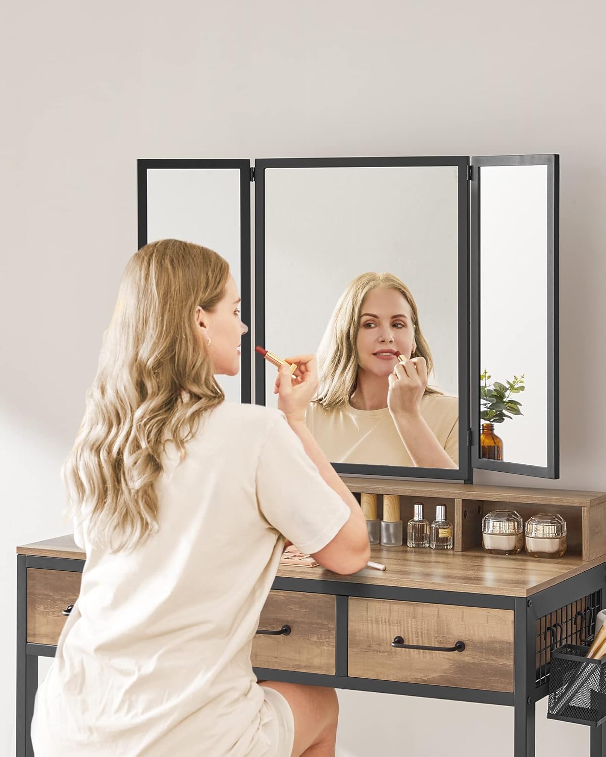 Person using the triple mirror vanity table