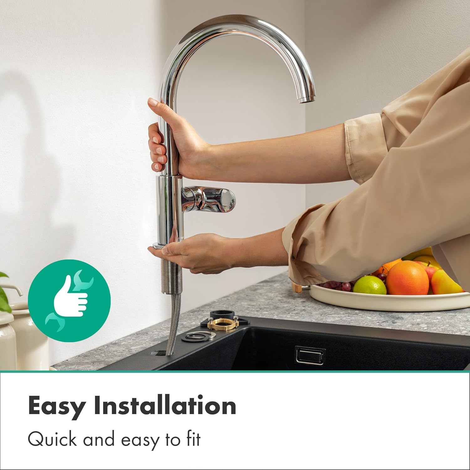 Hands installing the Hansgrohe Vernis Blend M35 Kitchen Mixer into a sink opening.