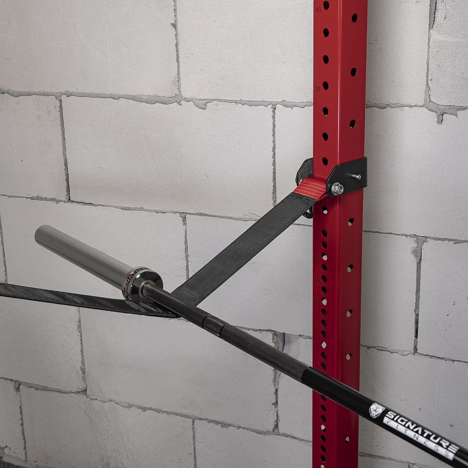 Close-up of a barbell resting on a Fitvids safety strap within a power cage.