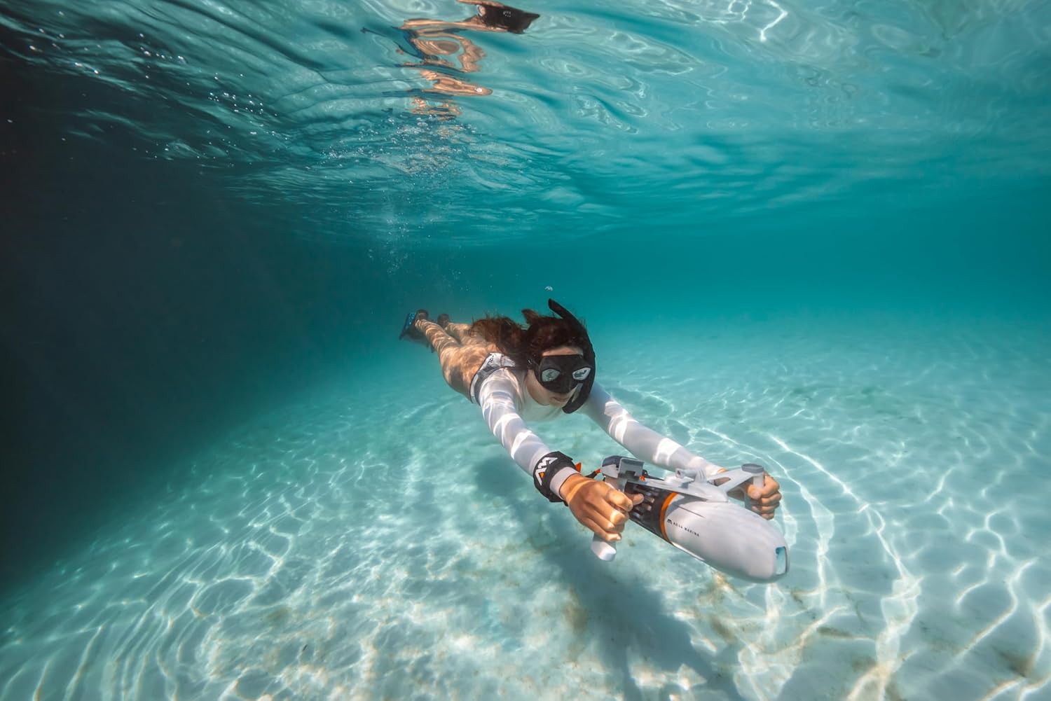 Person swimming underwater with the Aqua Marina Bluedrive X Pro from a rear view