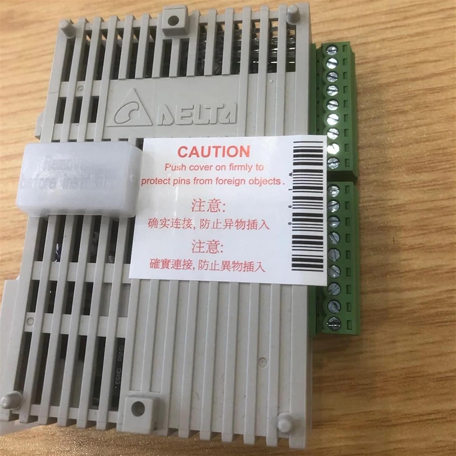 Top-down view of a Delta DVP06AD-S module with a caution sticker.