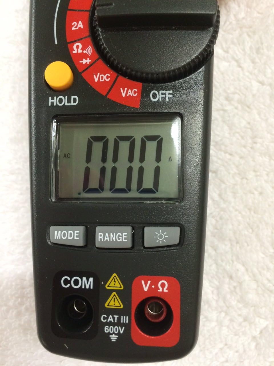 Bawah view of Craftsman 82372 clamp meter showing the LCD display, MODE, RANGE, and backlight buttons, and input jacks.