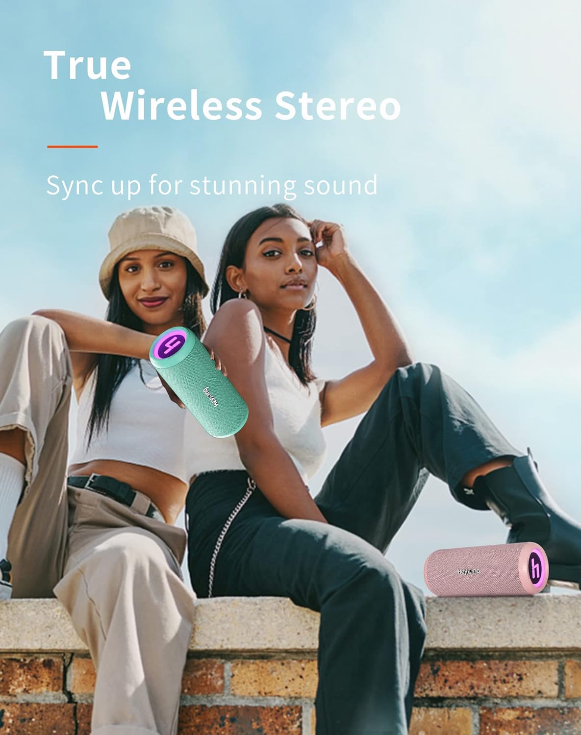 Two Heysong SONIC BLAST Bluetooth Speakers, one mint green and one pink, demonstrating True Wireless Stereo pairing.