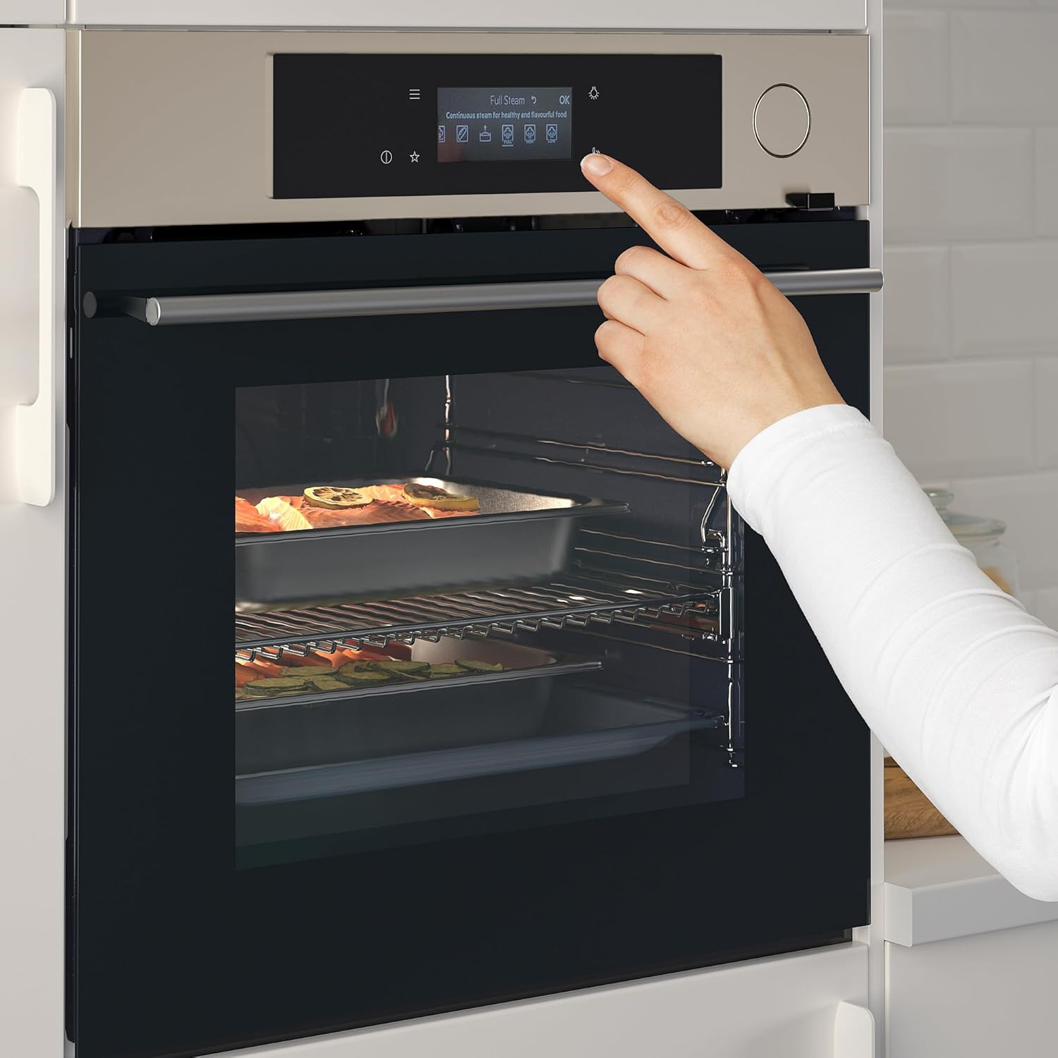A hand interacting with the oven's control panel, which displays 'Full Steam OK' and various steam icons