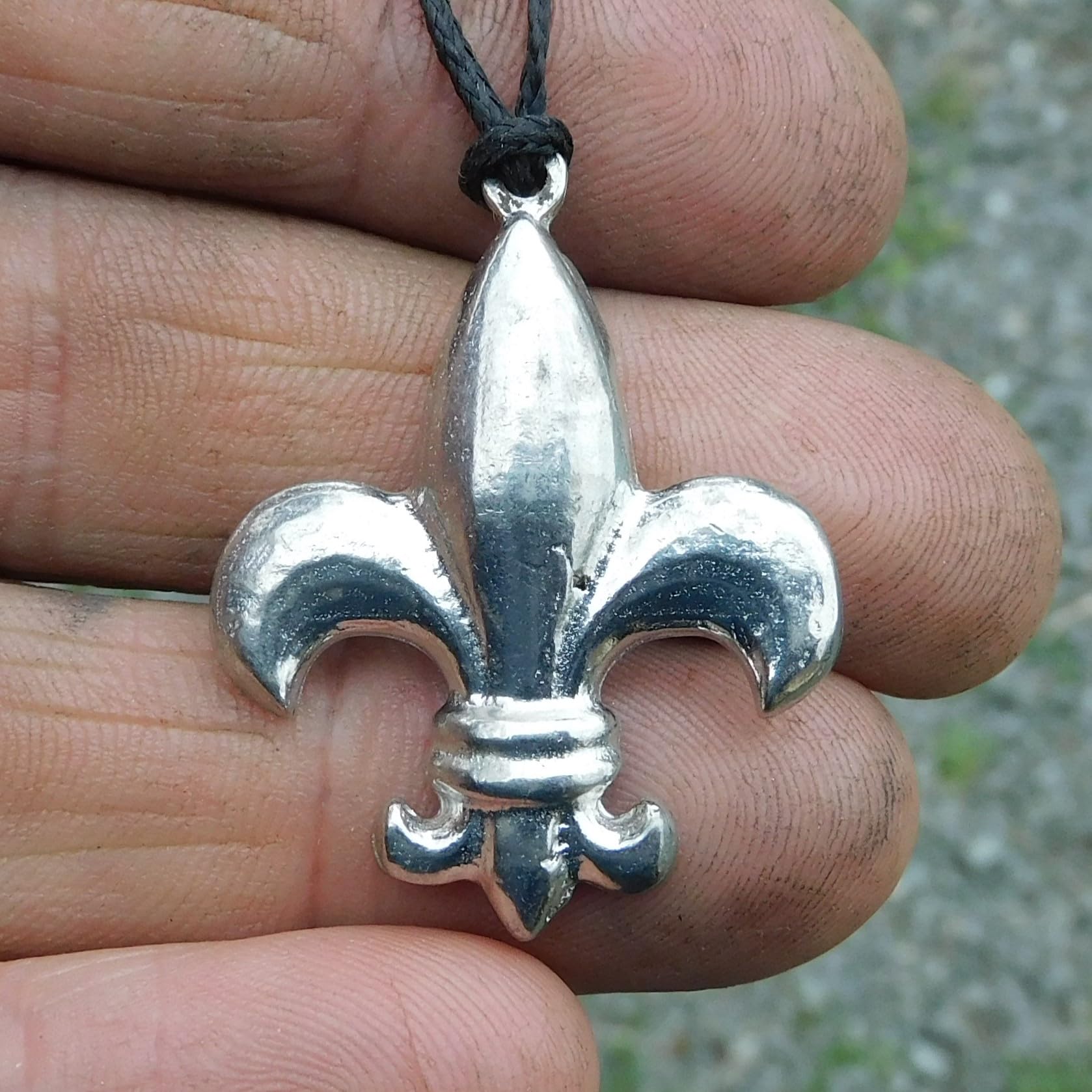 Pendentif fleur de lys fabriqué à la main par William chez les Étains de Jumilhac