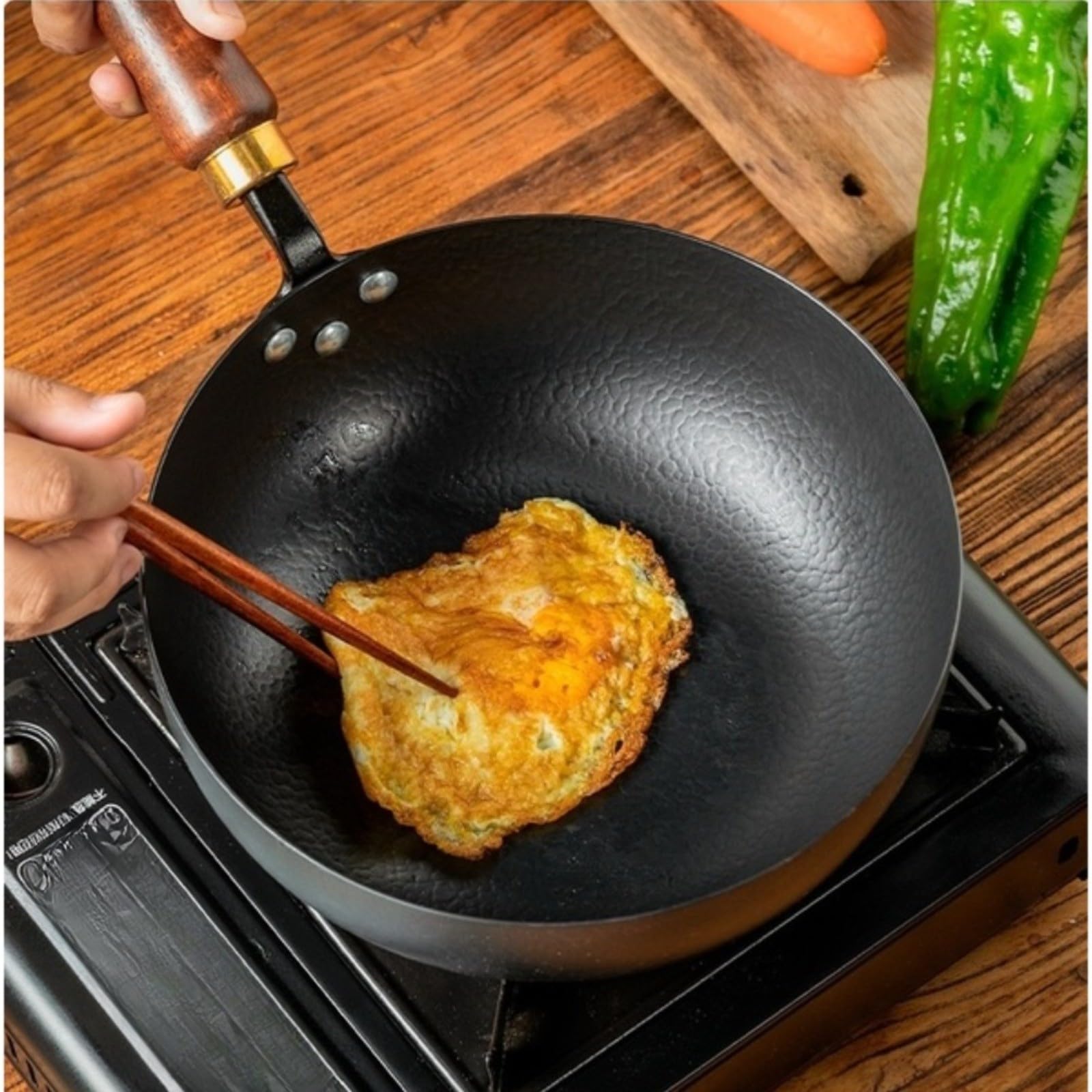 Hand-Hammered Cast Iron Wok 24 cm Wooden Handle | El compuesto de metal sólido se coloca en la zona de cocción, distribuye el calor de manera uniforme y facilita la cocción.