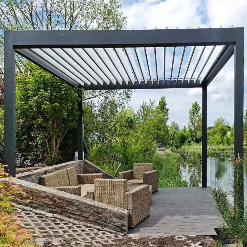 Dark grey bioclimatic pergola with open louvers by a pond
