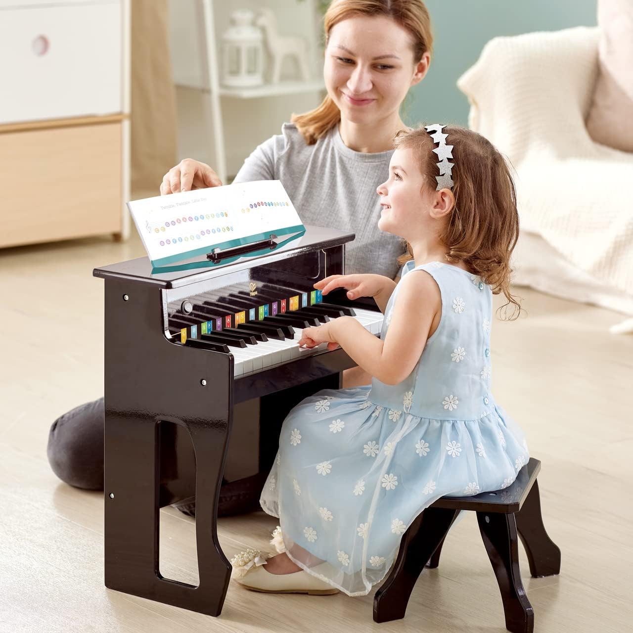 Child and adult playing the Hape piano together with a music sheet