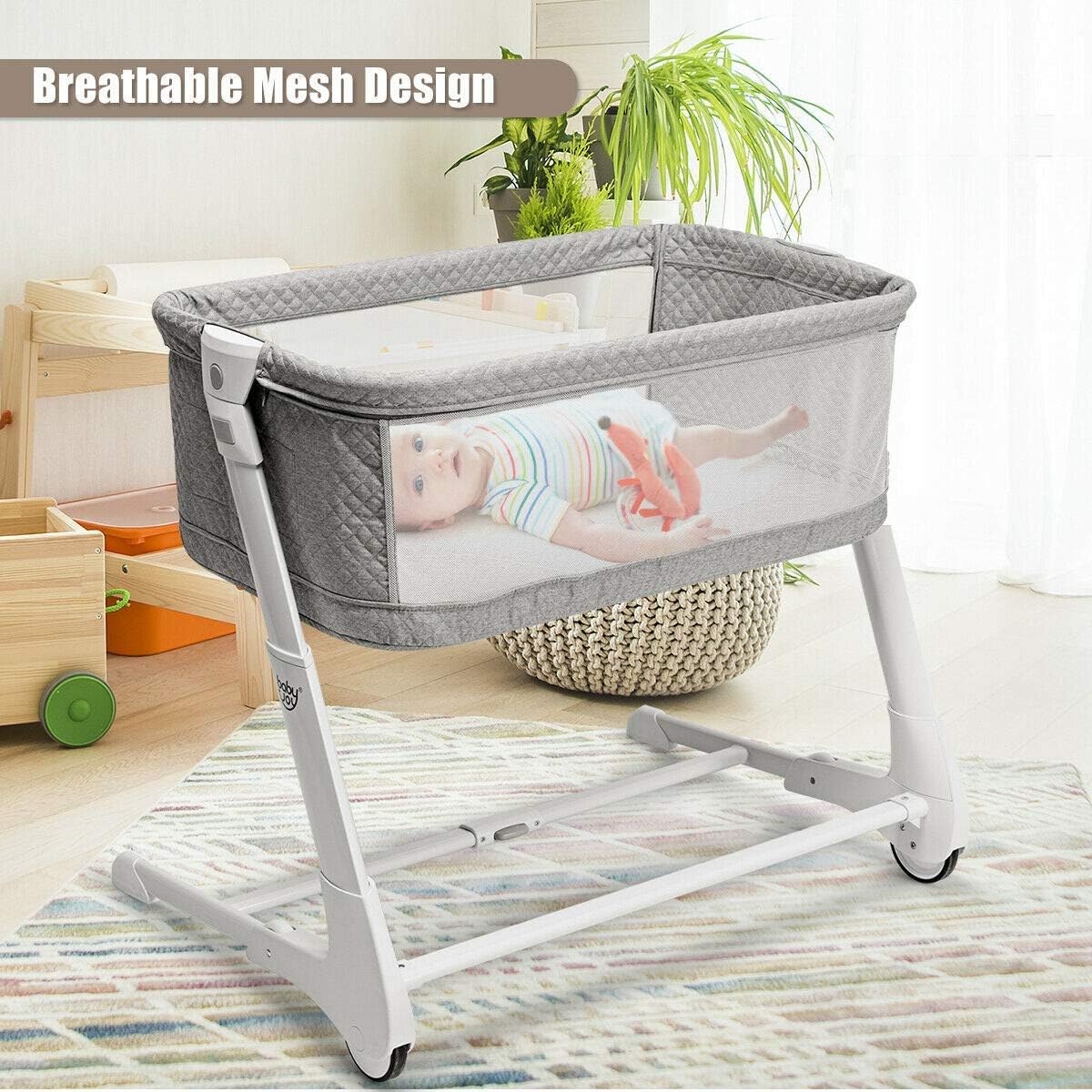 A baby lying in the BABY JOY Baby Bassinet, showcasing its breathable mesh design on the sides.
