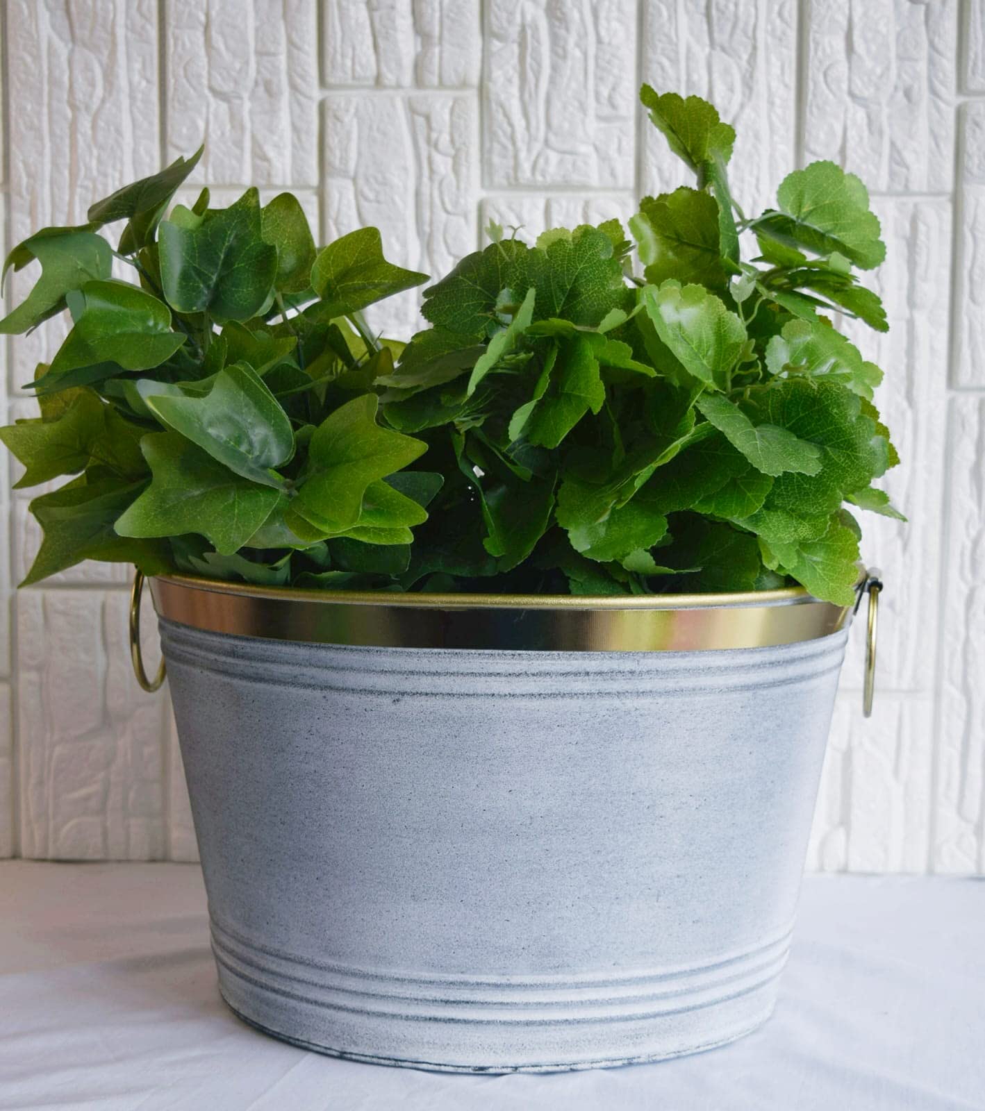 Rolli Brass Stripe Round Planter with Handle, Featuring a Striking EPL Brass and Distress White Finish and Expertly Constructed from Durable Galvanized Steel Material, Perfect for Home or Garden Use